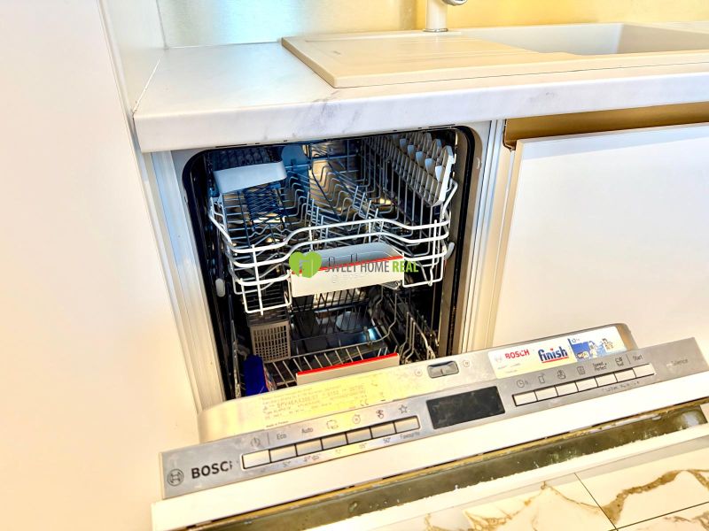 Die Spülmaschine in der Küche einer 3-Zimmer-Wohnung, offene Tür zeigt das Innere.