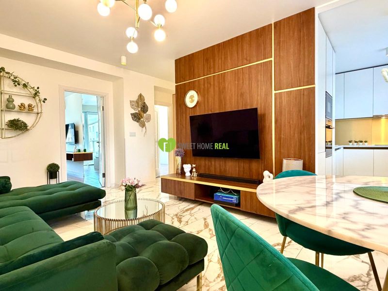 Wohnzimmer in einer 3-Zimmer-Wohnung mit Marmorboden und grünen Sofas.