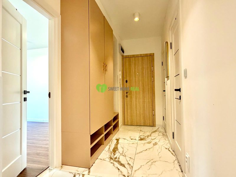Der Flur in der 3-Zimmer-Wohnung mit weißen Türen und einem Boden mit Marmordekor.