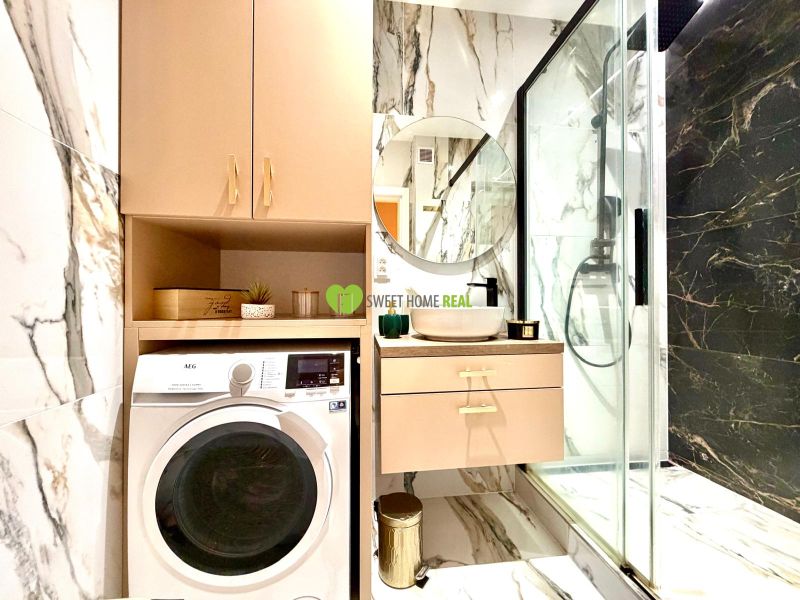 Badezimmer in einer 3-Zimmer-Wohnung mit Dusche, Waschbecken und Waschmaschine.
