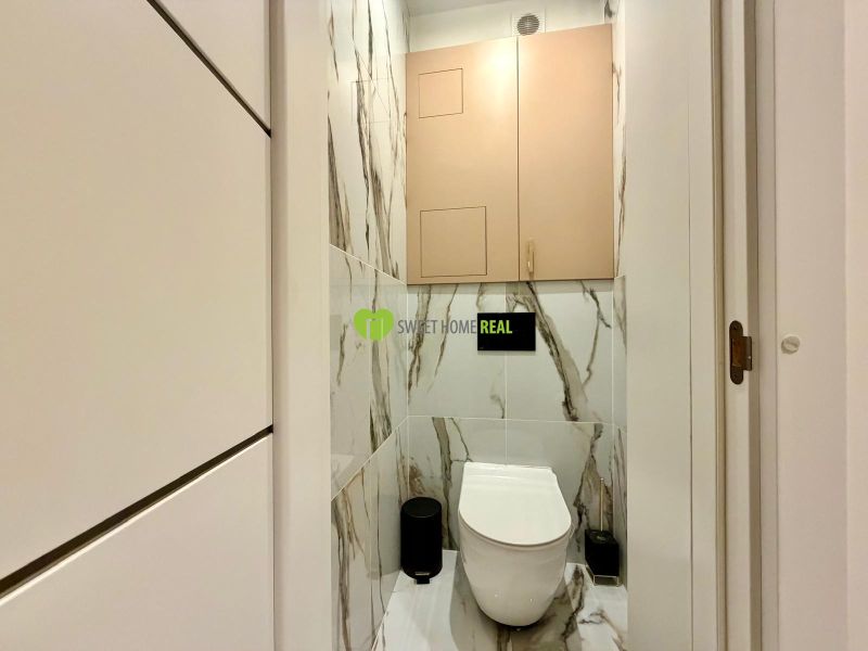 Badezimmer in einer 3-Zimmer-Wohnung mit Fliesen in Marmoroptik und hängendem WC.