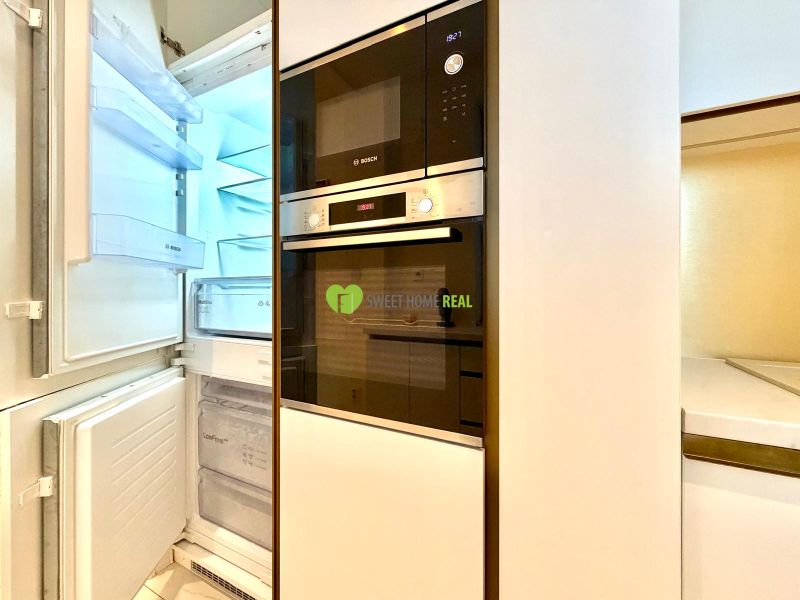 Küchenzeile mit Kühlschrank und eingebauten Geräten in einer 3-Zimmer-Wohnung.