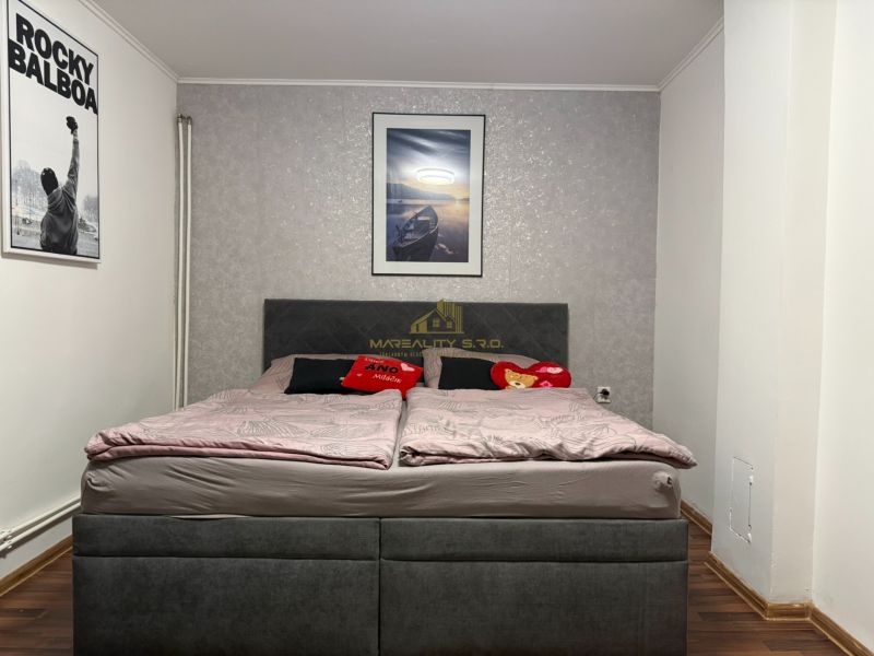 Schlafzimmer in einem Einfamilienhaus mit Bett, Holzboden und Rocky Balboa Poster.