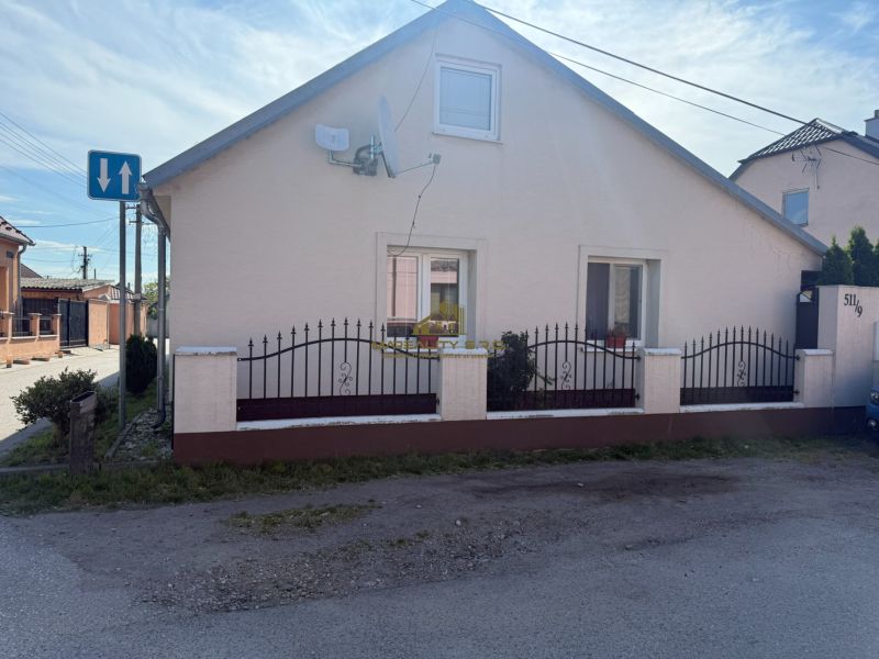 Ein Einfamilienhaus in Záhorská Ves mit weißer Fassade und schwarzem Metallzaun.
