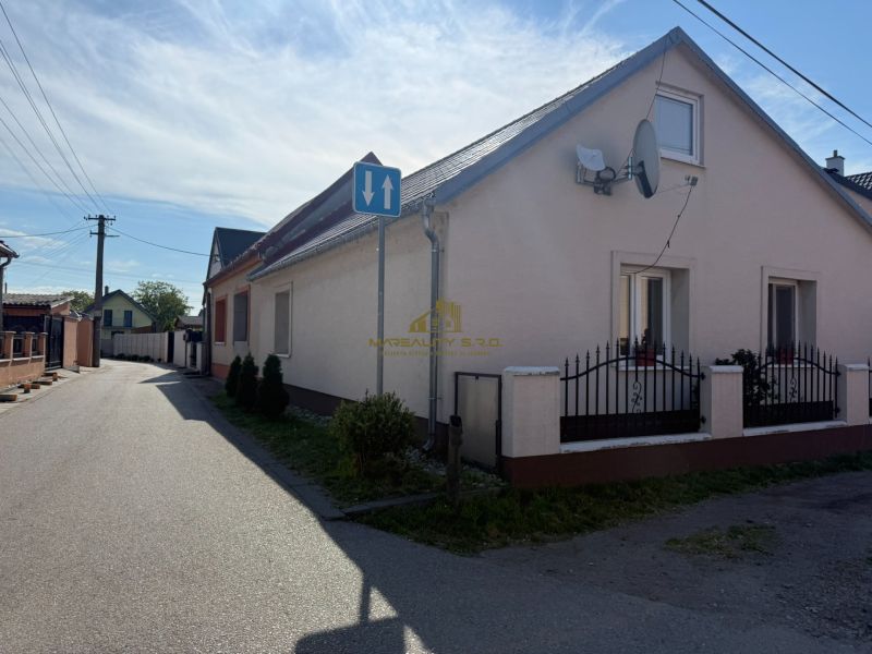 Ein Einfamilienhaus in Záhorská Ves mit einer Antenne und einer schmalen Zufahrtsstraße.