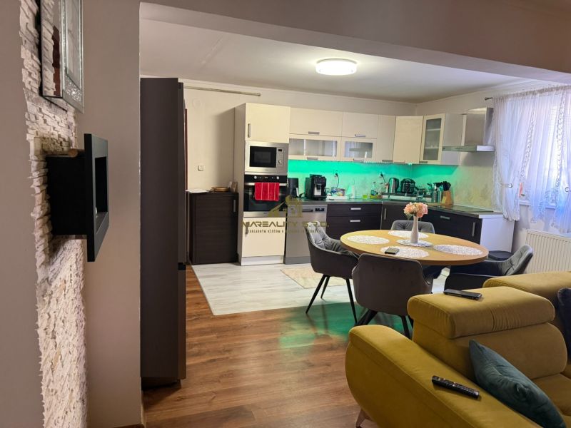 Küche mit Esstisch und Sofa, Boden mit Holzdekor in einem Einfamilienhaus.