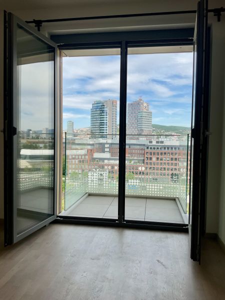 Blick auf das Zentrum von Bratislava aus einer 1-Zimmer-Wohnung mit Balkon und Holzboden.