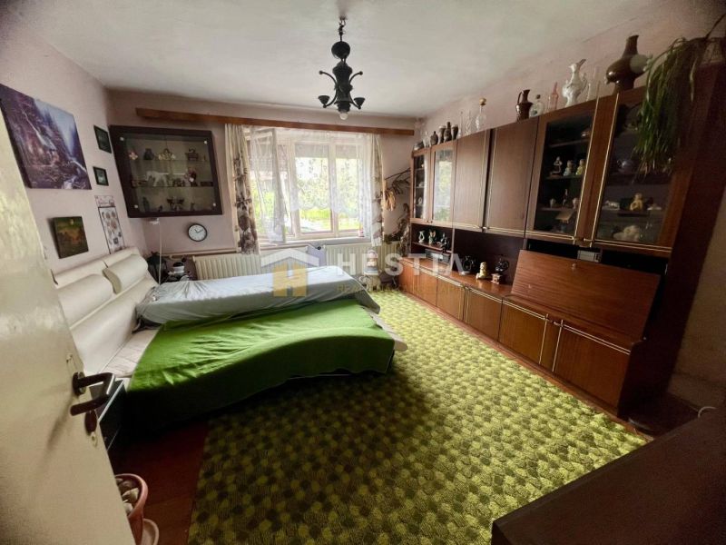 Schlafzimmer in einem Einfamilienhaus mit Teppichboden, Schrankwand und großem Fenster.