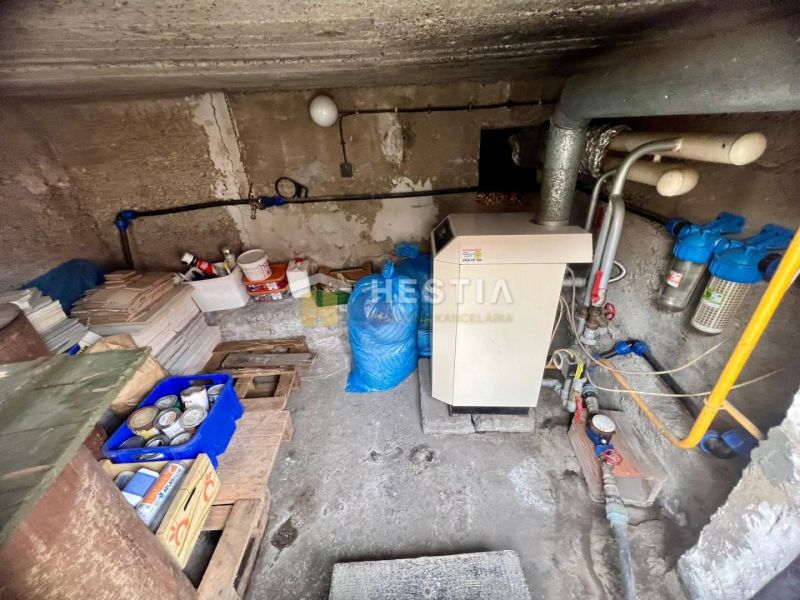 Technikraum in einem Einfamilienhaus mit Kessel und Leitungen, Stauraum für Materialien.