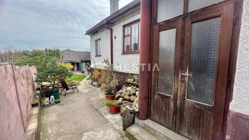 Ein Einfamilienhaus in Cerová mit Höfen und Grünflächen, gesäumt von Holz- und Steinelementen.