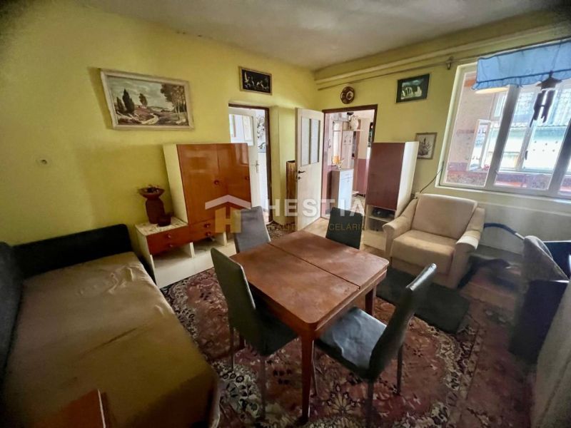 Wohnzimmer eines Einfamilienhauses mit Teppich, Holzmöbeln und Wandmalereien.
