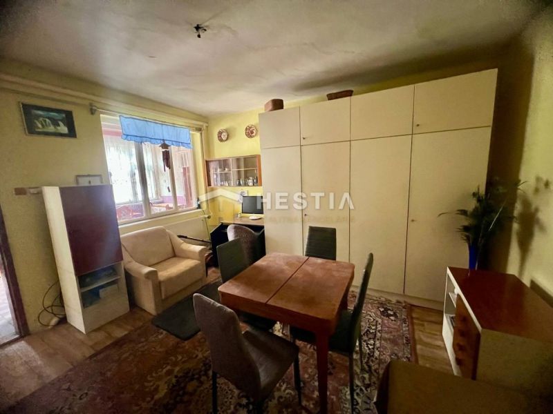 Wohnzimmer in einem Einfamilienhaus mit Schrank und Sofa, Boden mit Holzdekor.