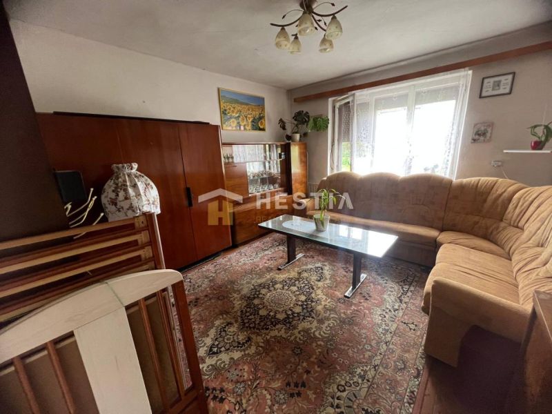 Wohnzimmer in einem Einfamilienhaus mit Teppich und verglastem Vitrinenschrank.