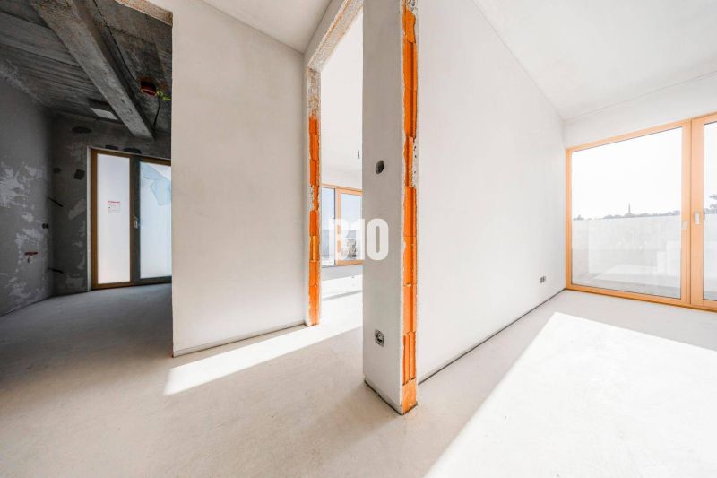 Innenraum einer 3-Zimmer-Wohnung mit großen Fenstern und Betondecke.