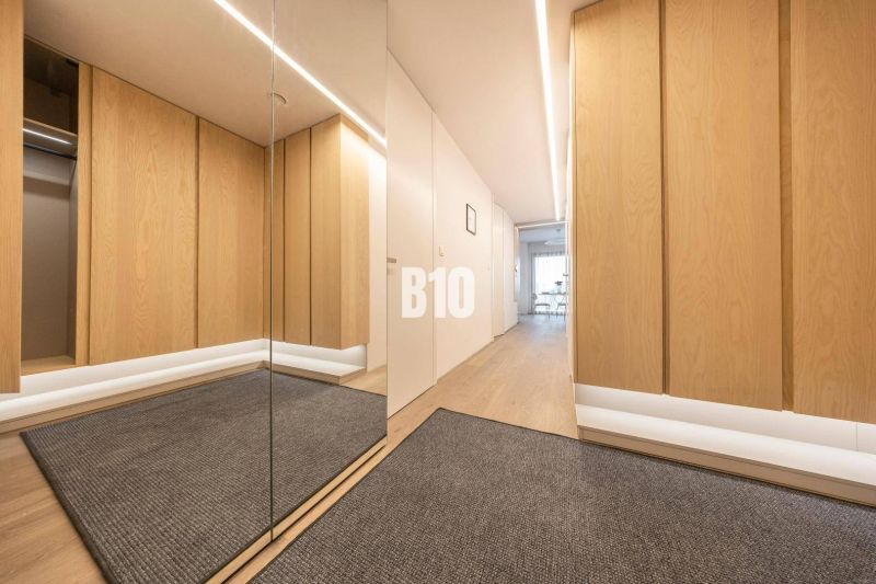 Flur in einer 3-Zimmer-Wohnung mit Holzboden und Spiegel.