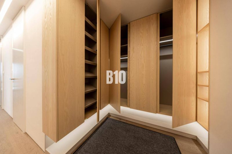 Ein Kleiderschrank mit Holztüren und einem Boden mit Holzdekor in einer 3-Zimmer-Wohnung.