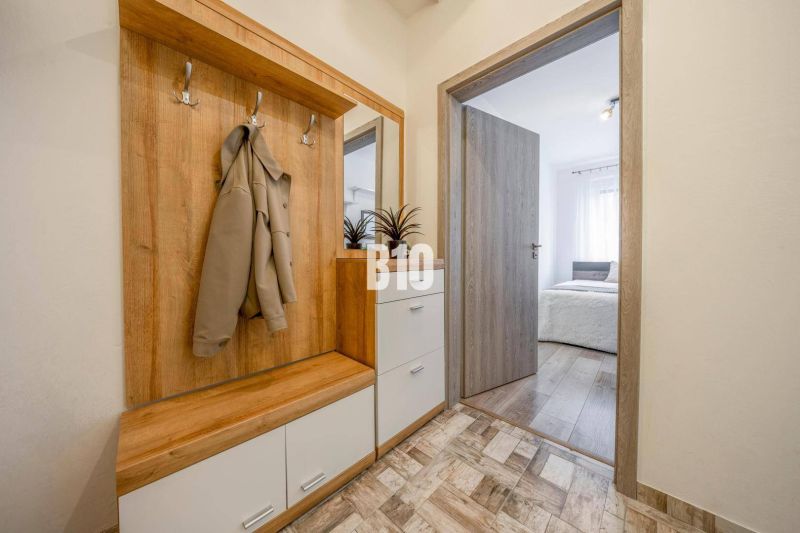 Eingangsflur mit Garderobenwand und Blick ins Schlafzimmer in einer 2-Zimmer-Wohnung.