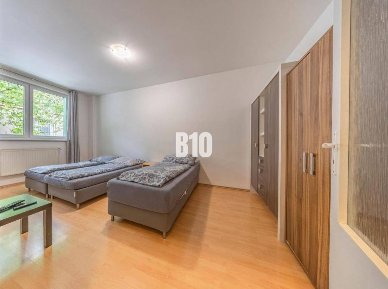 Schlafzimmer mit zwei Betten, einem Schrank und einem Fenster im Büro.