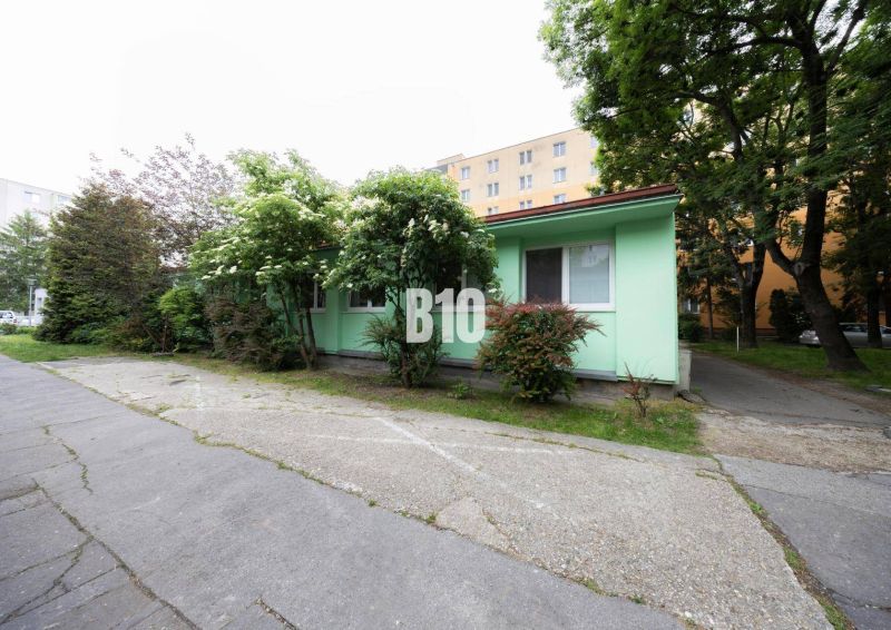 Ein einstöckiges Gebäude mit bunter Fassade, umgeben von Bäumen in Bratislava - Ružinov, Ostredky.
