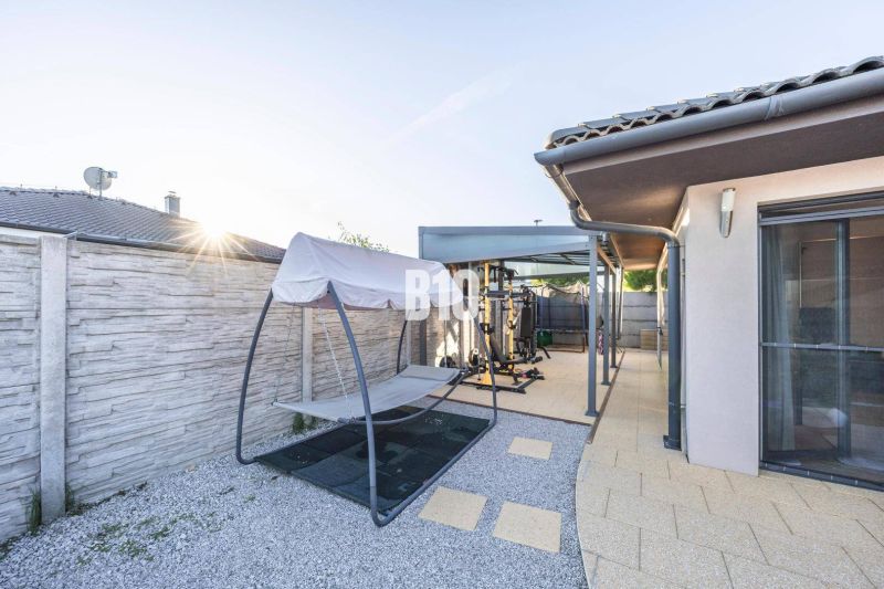 Ein Einfamilienhaus in Most pri Bratislave mit Terrasse, einem Außenfitnessstudio und einer Schaukel.