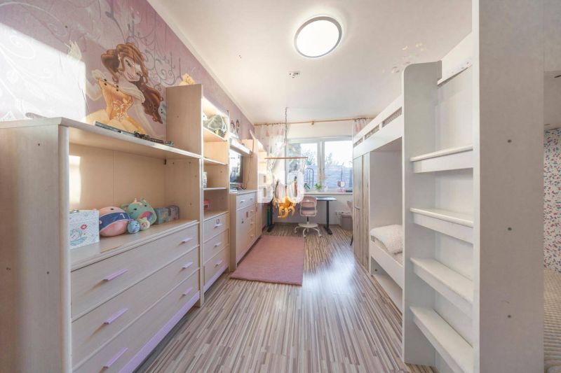 Kinderzimmer in einem Einfamilienhaus mit einem Etagenbett und einem Boden in Holzoptik.