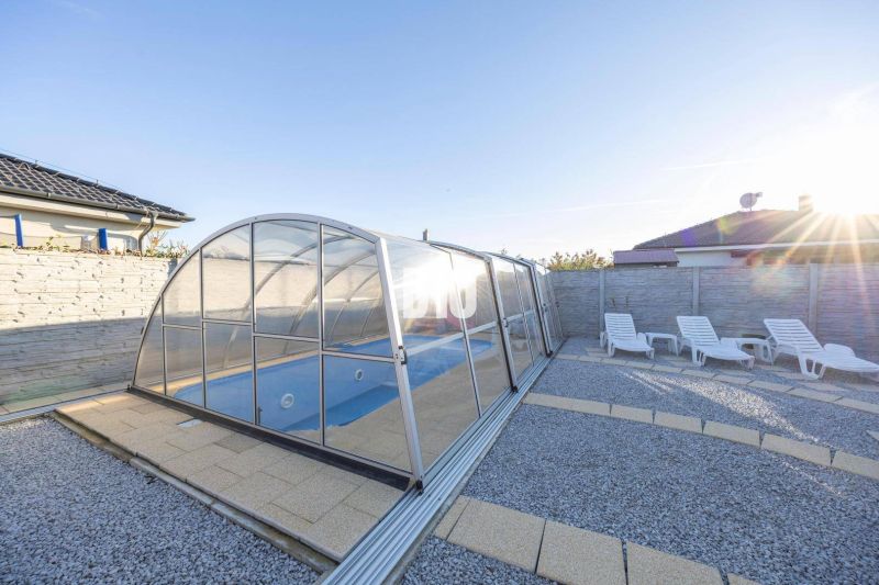 Der Garten eines Einfamilienhauses in Most pri Bratislave mit einem Pool und Liegestühlen.