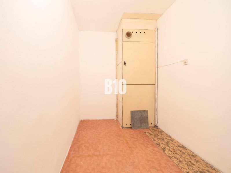 Ein schmaler Raum in einer 4-Zimmer-Wohnung mit einem Boden in Holzoptik und einem Schrank.