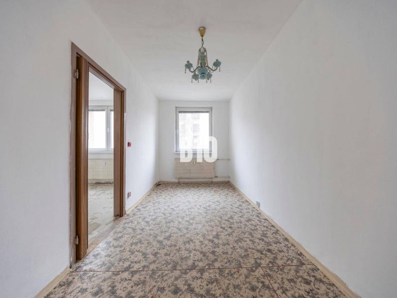 Ein schmales Zimmer in einer 4-Zimmer-Wohnung mit Teppichboden und einem Vintage-Kronleuchter.
