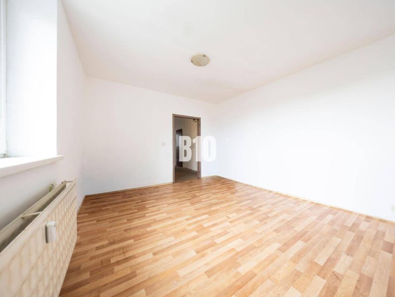 Helles Zimmer mit Wänden in einer 4-Zimmer-Wohnung und einem Boden mit Holzdekor.