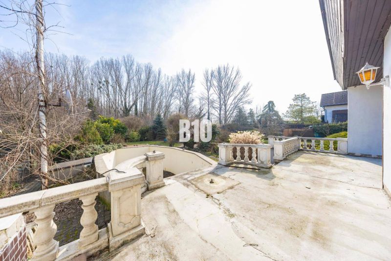 Die Terrasse des Einfamilienhauses in der Donau-Straße in Hamuliakovo mit einem großen Garten und Blick auf die Bäume.