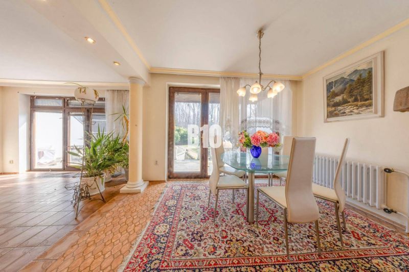 Esstisch in einem Einfamilienhaus mit Teppichen und Blumen auf dem Tisch.