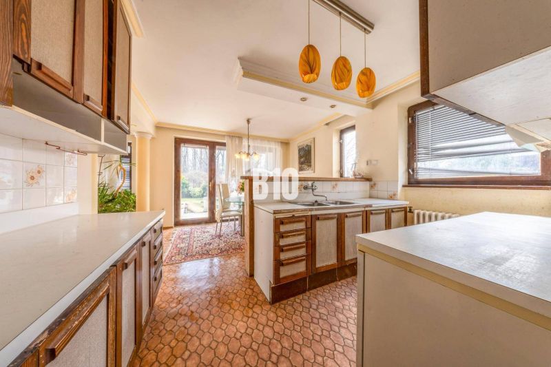 Küche in einem Einfamilienhaus mit Esszimmer, Fenstern und Zugang zum Garten.