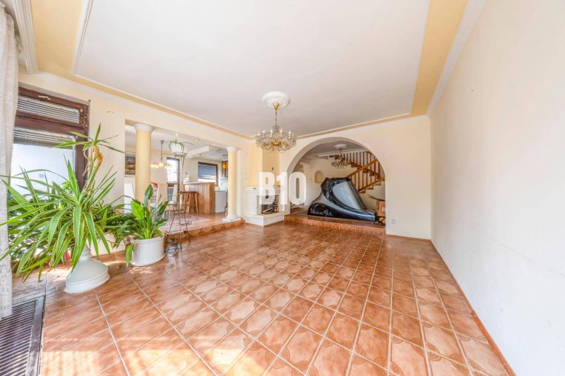 Innenraum eines Einfamilienhauses mit Keramikboden, Treppe und Zimmerpflanzen.