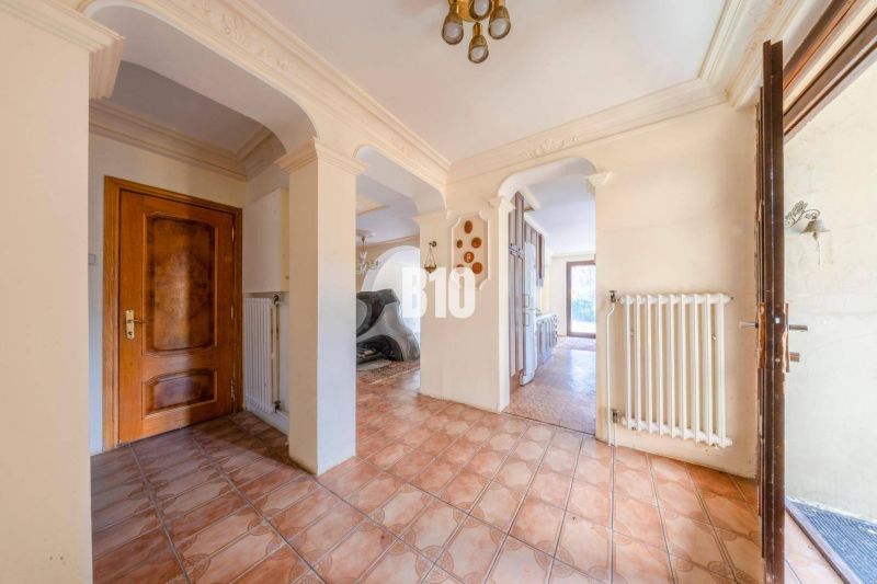 Flur in einem Einfamilienhaus mit verziertem Decke und braunen Türen.
