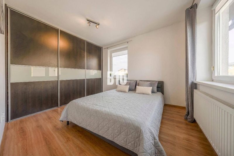 Schlafzimmer in einer 2-Zimmer-Wohnung mit Holzboden und großem Einbauschrank.