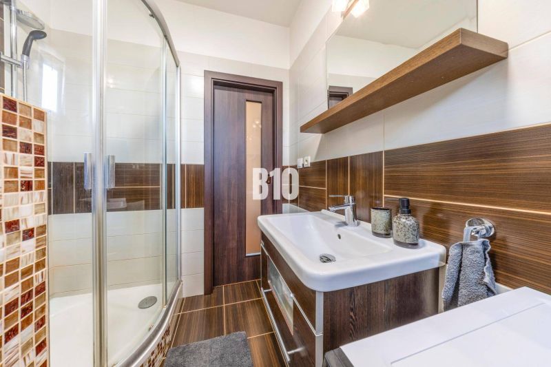 Das Badezimmer in der Zweizimmerwohnung hat eine Dusche und einen Waschtischunterschrank.
