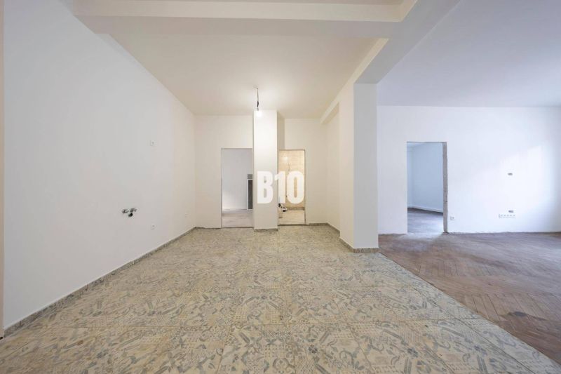 Ein geräumiges Zimmer in einer 3-Zimmer-Wohnung mit Keramik- und Holzboden wartet auf eine Renovierung.