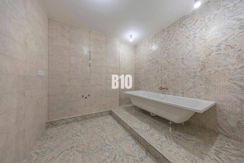 Ein Badezimmer in einer 3-Zimmer-Wohnung mit einer Badewanne und dekorativen Fliesen.