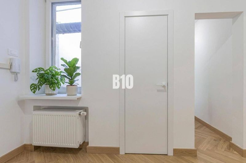 Innenraum einer 3-Zimmer-Wohnung mit Pflanzen auf der Fensterbank und einem Boden in Holzoptik.