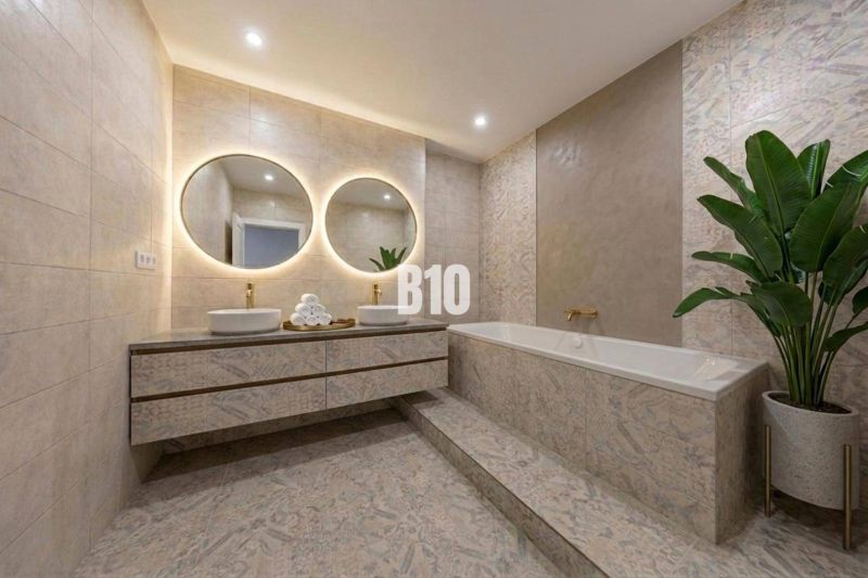 Elegantes Badezimmer mit Badewanne, Doppelwaschbecken und großen Spiegeln in einer 3-Zimmer-Wohnung.