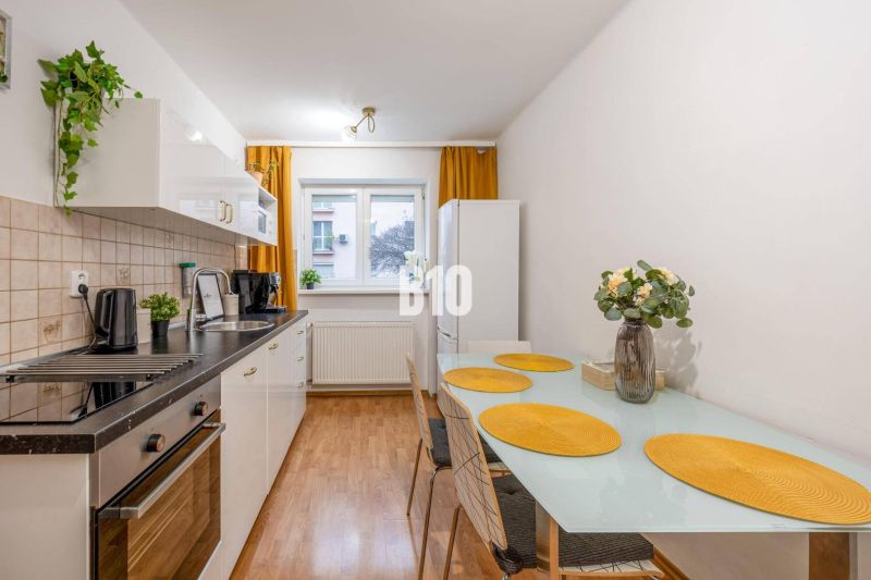 Küche in einer 2-Zimmer-Wohnung mit Esstisch und weißer Küchenzeile.