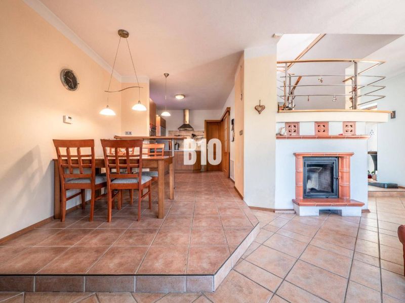 Esszimmer mit Kamin und Küche in einem Einfamilienhaus mit Keramikfliesen.