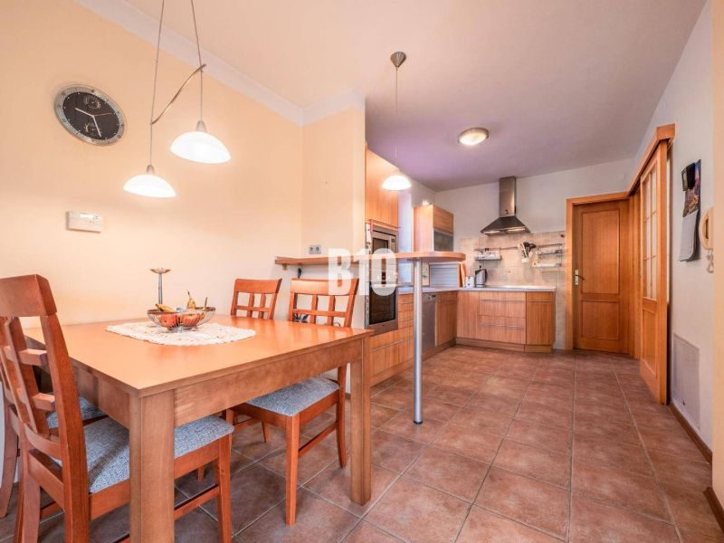 Küche in einem Einfamilienhaus mit Holzmöbeln und Keramikfliesen.