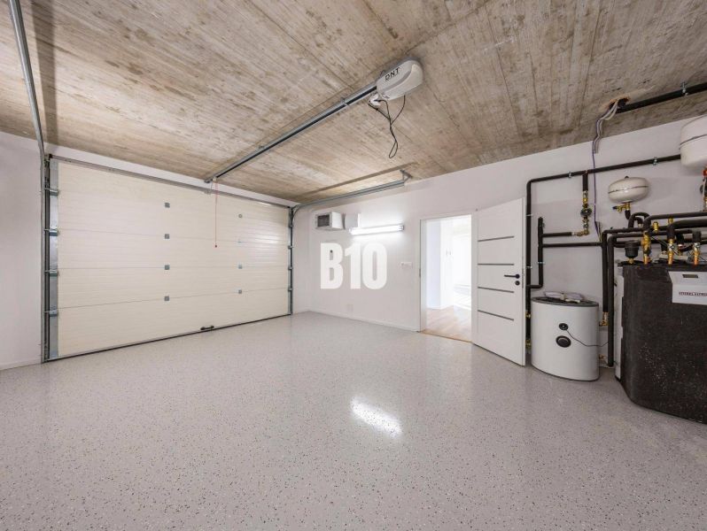 Garage in einem Einfamilienhaus mit Tor und Kessel, ohne Holzdekor auf dem Boden.