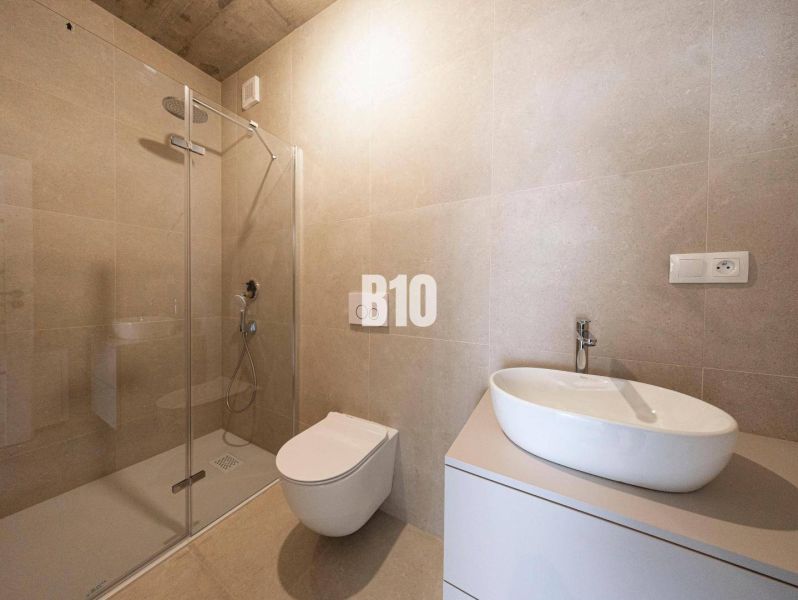Badezimmer im Einfamilienhaus mit Duschkabine, Toilette und Waschbecken auf einem Schrank.