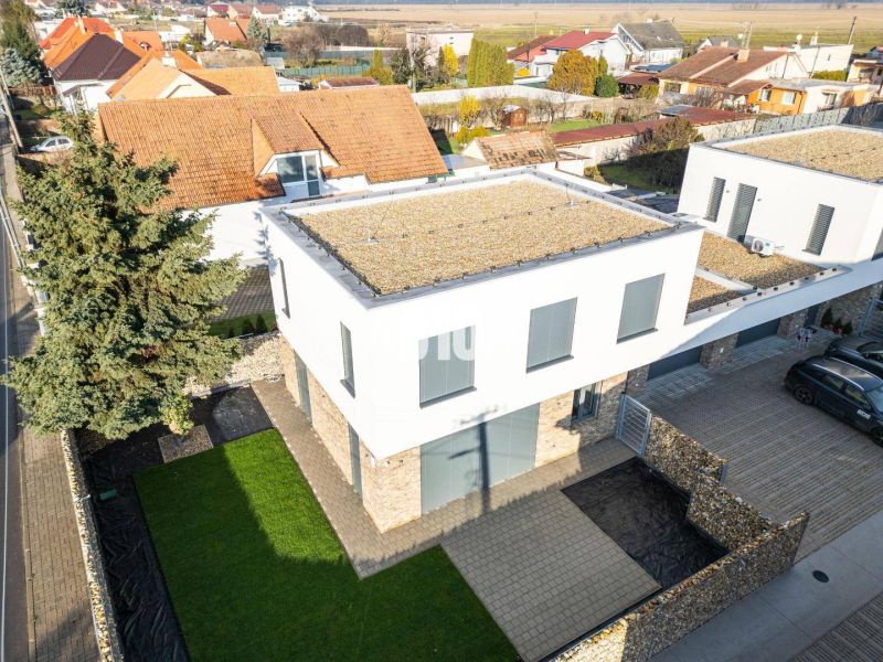 Ein Einfamilienhaus in der Ivanská Straße in Malinovo mit grünem Rasen und befestigtem Weg.