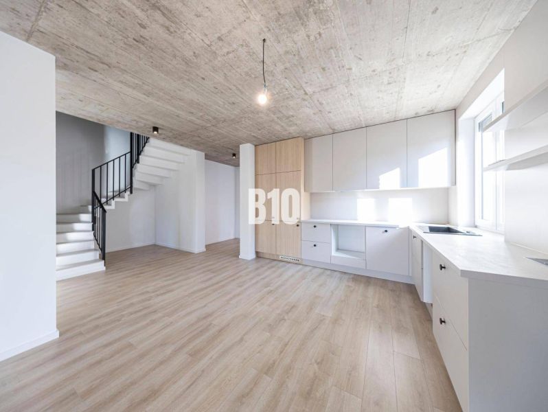Innenraum eines Einfamilienhauses mit Küche, Treppe und Boden in Holzoptik.