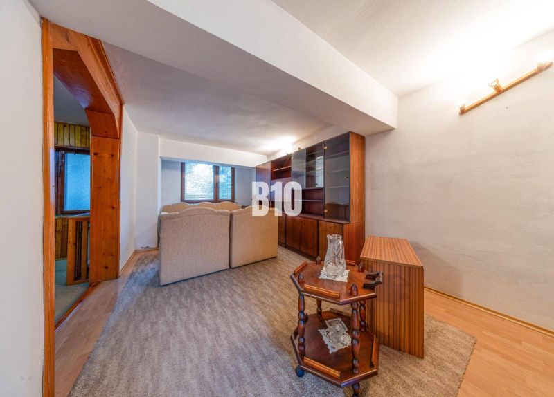Wohnzimmer in einem Einfamilienhaus mit Perspektive auf Holzmöbel und bequeme Sitzgarnituren.