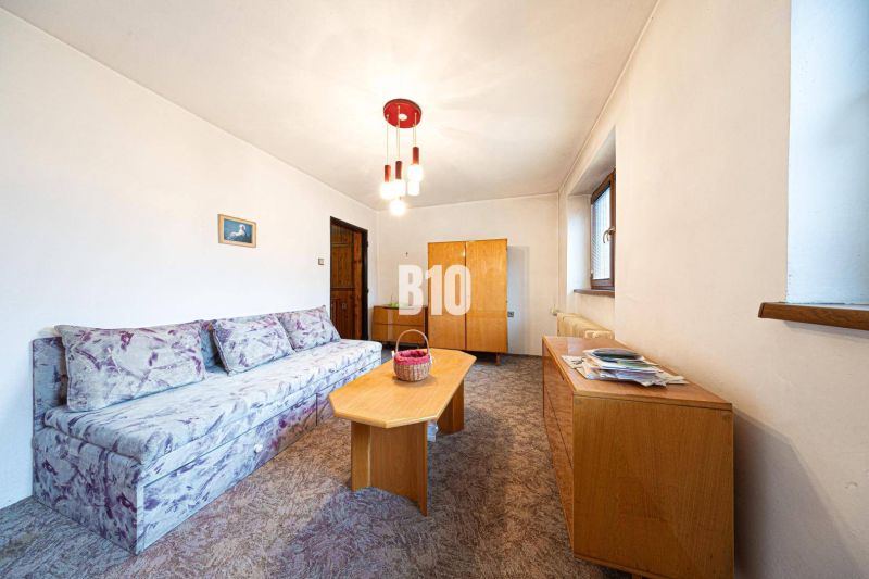 Wohnzimmer in einem Einfamilienhaus mit Sofa und Holzmöbeln.