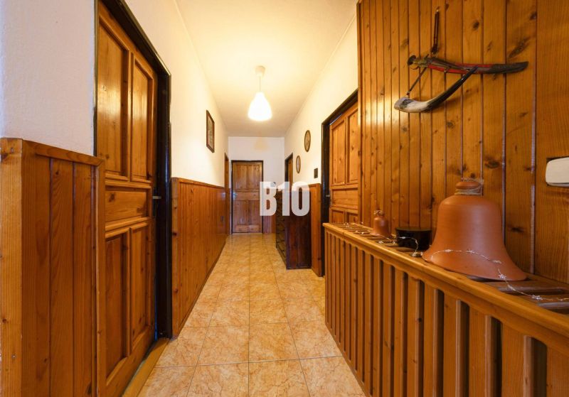 Ein Flur in einem Einfamilienhaus mit Holzverkleidung und Tongefäßen zur Dekoration.